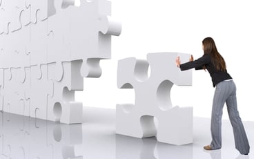 business teamwork - businesswoman building a puzzle which was made in 3d over a white background