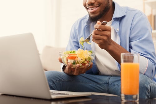 cheerful-african-american-man-eating-healthy-lunch-QT9DXS8